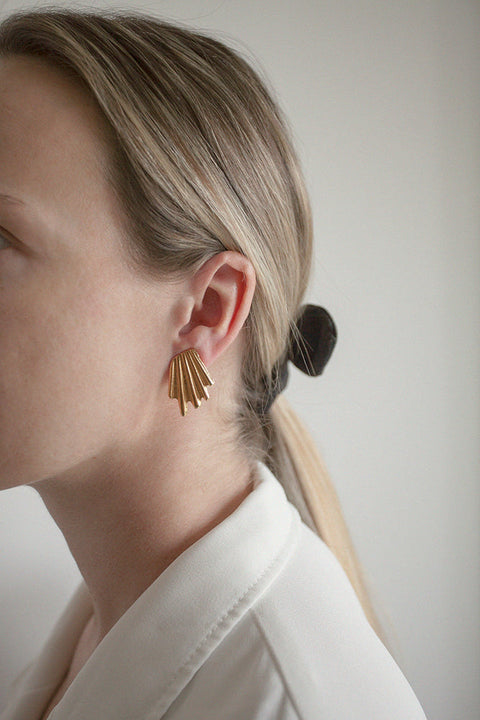Elegant ear clips inspired by the form of broken shells. Featuring a sculptural, dynamic design, these statement clips add character and sophistication to any look. Measuring 20 x 27 mm, they are a striking choice for those who appreciate bold yet refined jewelry. Discover expressive elegance by UMIAR jewelry.