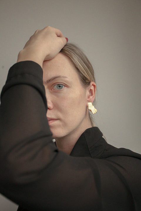 Elegant ear clips inspired by broken shells, designed as a summer statement in a refined form. Measuring 15 x 29 mm, they offer a stylish alternative to pierced earrings and add character to warm-weather looks. A sculptural accent that blends ease with elegance. Discover summer-ready design by UMIAR jewelry.