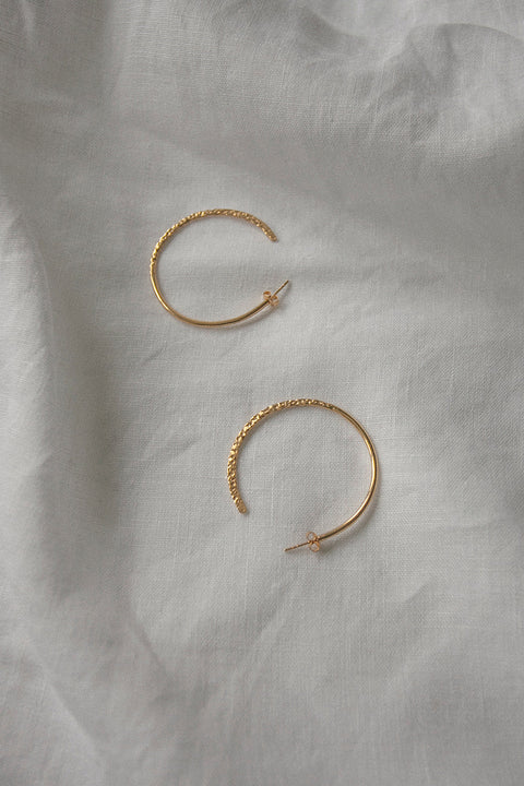 Hoop earrings with a distinctive evolving texture that shifts from hammered to smooth, polished finish. Featuring a bold 45 mm diameter, they offer an expressive yet elegant accent that enhances both minimalist and statement styling. Discover refined craftsmanship and modern design by UMIAR jewelry.