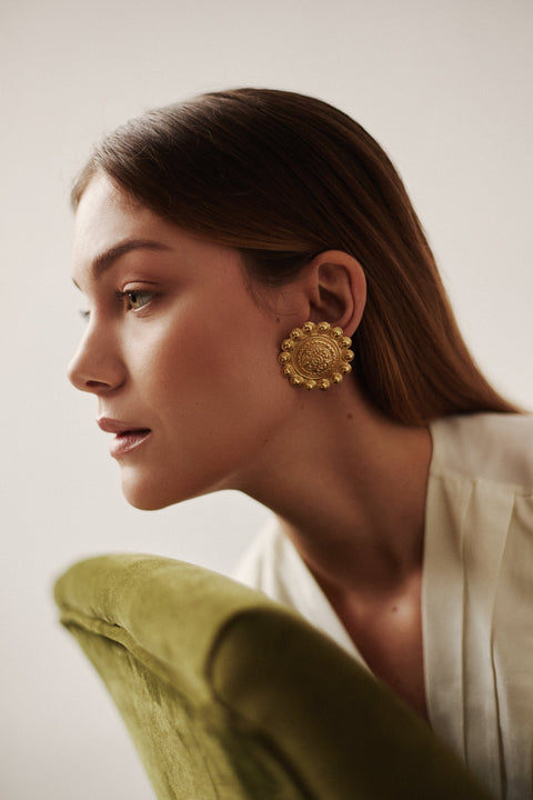 Large vintage-inspired stud earrings with rich ornamentation and symbolic sun motifs. Featuring a 40 mm diameter, they create a bold, eye-catching statement and evoke the spirit of mythical Mediterranean Greece. A striking design for those who dream of travel and timeless elegance. Discover expressive jewelry by UMIAR jewelry.