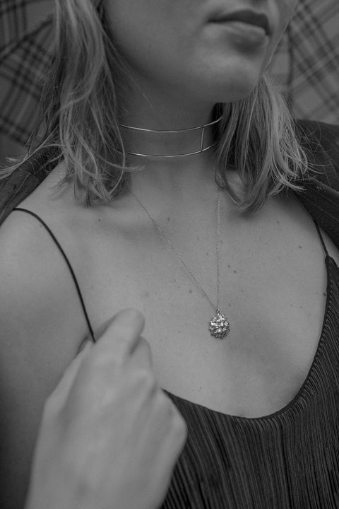 A unique minimalist choker combining two ORA hoops with vertical crossbars. Handcrafted for individuality, this avant-garde design offers modern elegance and architectural form. A refined statement piece that enhances both casual and elevated styling. Discover contemporary minimalism by UMIAR jewelry.