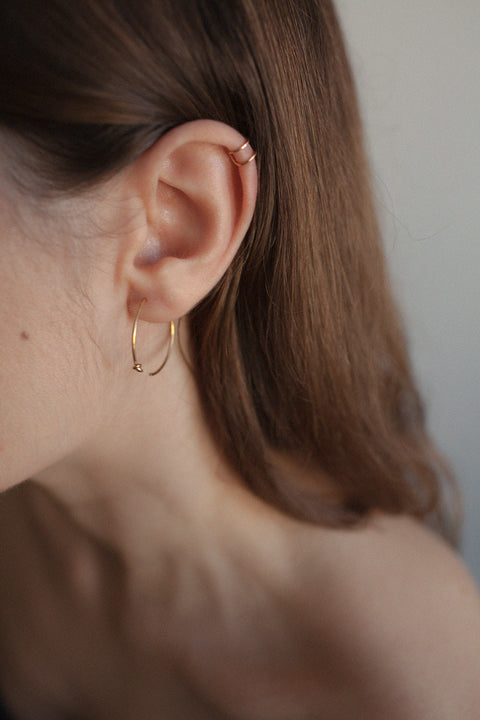 Discover the handcrafted ear cuff from UMIAR jewelry, made from a silver rod shaped into a doubled letter C. This delicate piece, available in 925 sterling silver or 24k gold-plated sterling silver, adds subtle elegance and a modern touch to any look. Designed to be worn on the upper part of the ear. Order now and highlight your unique style with UMIAR jewelry!