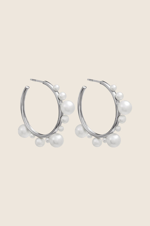 Discover the elegant and expressive hoop earrings adorned with natural pearls of varying sizes by UMIAR Jewellery. Their unique design makes them not only a beautiful accessory but also a bold statement piece in your look. Wear them on their own or paired with GEMINA inserts. Handcrafted from noble materials — 925 sterling silver and 24k gold-plated sterling silver. Find your unique style today!