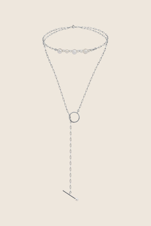 An exceptionally striking choker necklace from UMIAR Jewellery, showcasing a beautiful variety of natural pearls, a delicate chain, and an asymmetrical circular pendant. Handcrafted with care, it is available in both 925 sterling silver and 24k gold-plated sterling silver. This blend of design and craftsmanship creates a unique piece of jewellery that radiates elegance and style.