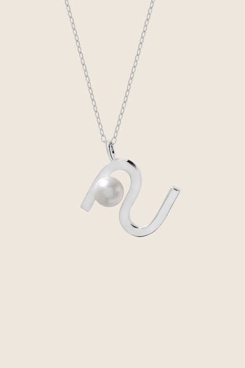An elegant necklace from UMIAR Jewellery featuring a unique wave-monogram form that gently frames a delicate natural pearl. Handcrafted in 925 sterling silver and 24k gold-plated 925 silver, it radiates refined style and meticulous craftsmanship. Every element of this design blends inspiration with artisanal precision, creating a distinctive piece that complements any look.