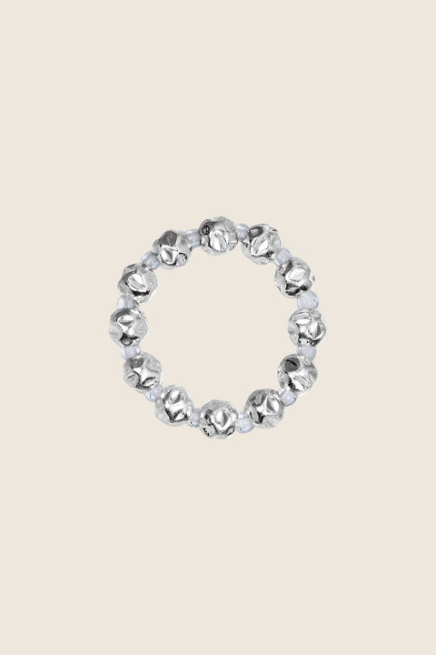 Discover the elastic jeweller’s-cord ring by UMIAR Jewellery, crafted from round beads and delicate rock crystals. Subtle and elegant, it adjusts perfectly to the finger, making it a refined accent for any look. Handcrafted with care, available in 925 sterling silver and 24k gold-plated 925 silver. Order now and add a touch of sophistication to your collection!