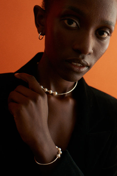 Discover refined elegance with this UMIAR Jewellery necklace that blends minimalism with subtle sophistication. Featuring a delicate silver tube combined with a strand of natural pearls and fine 925 silver beads, it embodies the essence of the MÉLANGÉ collection — a fusion of beaded jewellery’s freedom with the refinement of pearls, gold and silver. By mixing materials and styles, we create harmony and balance in every detail. Explore now and add a touch of luxury to your look!