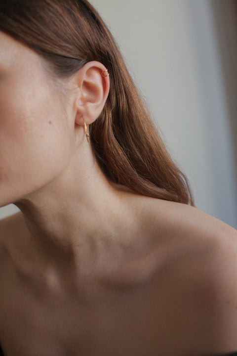 Discover the handcrafted ear cuff from UMIAR jewelry, made from a silver rod shaped into a doubled letter C. This delicate piece, available in 925 sterling silver or 24k gold-plated sterling silver, adds subtle elegance and a modern touch to any look. Designed to be worn on the upper part of the ear. Order now and highlight your unique style with UMIAR jewelry!