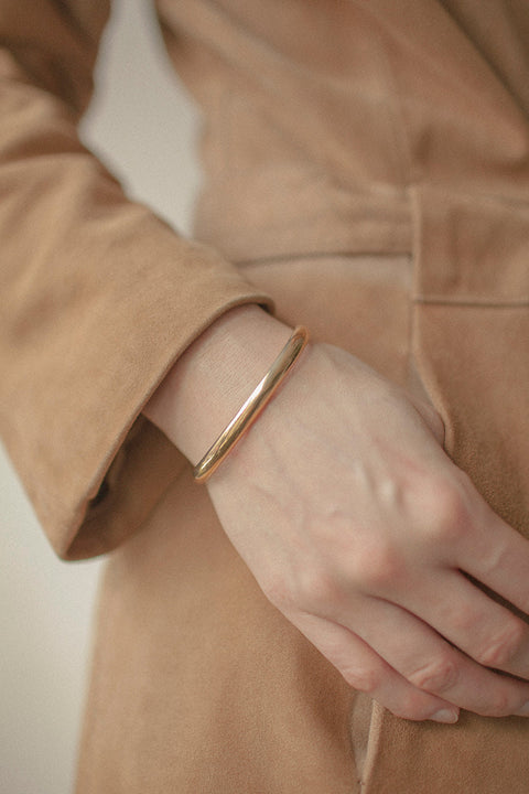 A minimalist bracelet crafted from a rigid silver tube with a distinctive semi-circular cross-section. Clean, elegant, and architectural, it offers a refined statement that complements both everyday and elevated styling. Discover timeless simplicity and modern form by UMIAR jewelry.