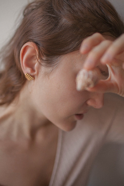 Delicate stud earrings inspired by broken shell forms create a subtle yet expressive summer accent. Measuring 18 × 15 mm, they add lightness and elegance to warm-weather looks, making them a versatile choice for everyday summer styling. Discover refined seasonal jewelry by UMIAR jewelry.