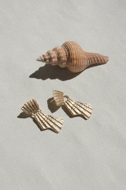 Decorative stud earrings inspired by broken shell forms, featuring a movable element for dynamic expression. Measuring 40 × 20 mm, they bring movement and character to summer styling. A distinctive yet elegant design that elevates warm-weather looks. Discover seasonal statement jewelry by UMIAR jewelry.