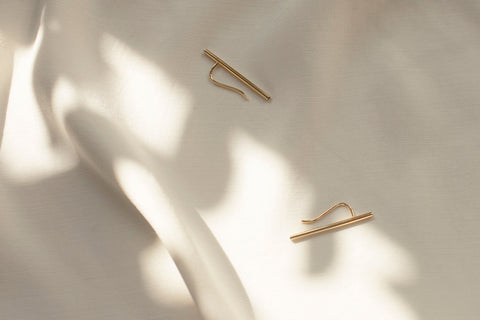 Monolithic earrings featuring a tubular form and fine threader wire, designed for versatile styling. Wear them as a sleek line along the earlobe or as a dangling accent. A sculptural, minimalist piece that combines modern design with effortless adaptability. Discover contemporary jewelry by UMIAR jewelry.