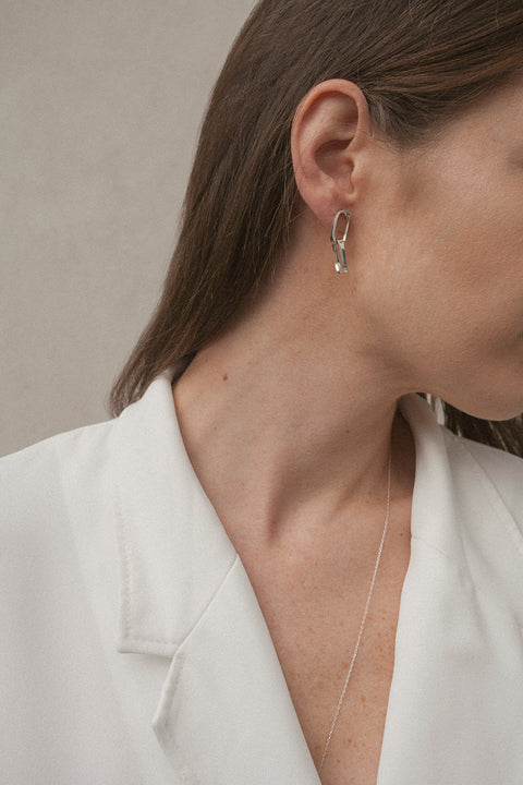 Minimalist drop stud earrings inspired by chain links, featuring clean, geometric rectangular forms. Lightweight yet expressive, with a length of approx. 28 mm, they offer timeless elegance suitable for everyday wear and special occasions alike. Discover refined minimalism by UMIAR jewelry.