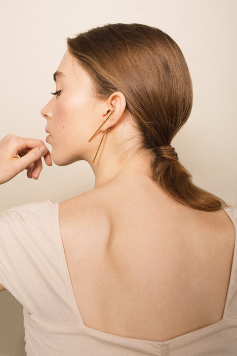 Extraordinary double-sided earrings featuring two dynamic straight lines and a distinctive layered construction. Composed of a front stud, back tube, and stopper, they create a modern, architectural statement that elevates any look. Discover contemporary design and refined craftsmanship by UMIAR jewelry.