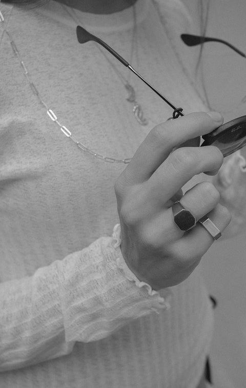 A minimalist square signet ring with softly cut corners and a smooth, polished finish. Designed as a unisex piece, it offers timeless elegance and modern simplicity. Featuring a 12 × 12 mm face, it is a refined everyday accessory for those who appreciate clean, contemporary design. Discover understated sophistication by UMIAR jewelry.