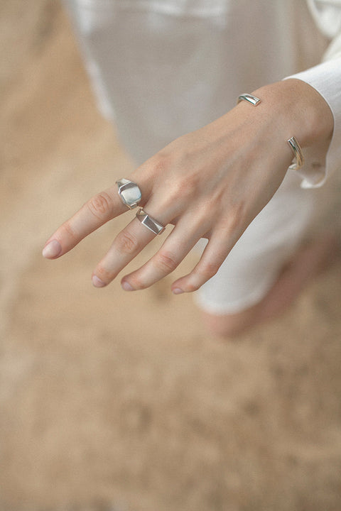 A minimalist square signet ring with softly cut corners and a smooth, polished finish. Designed as a unisex piece, it offers timeless elegance and modern simplicity. Featuring a 12 × 12 mm face, it is a refined everyday accessory for those who appreciate clean, contemporary design. Discover understated sophistication by UMIAR jewelry.