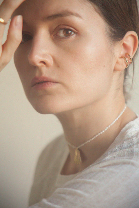 A refined choker necklace combining a silver broken shell pendant with natural pearls. Featuring an adjustable chain and a total length of 46 cm, it can be worn close to the neck or slightly lower for versatile styling. A modern marine accent that blends elegance with natural beauty. Discover contemporary seaside jewelry by UMIAR jewelry.