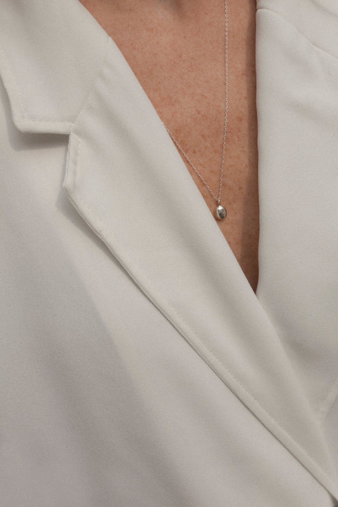 A distinctive pendant inspired by the organic shape of a droplet, suspended on a 50 cm chain. Each piece is subtly unique, highlighting its handcrafted character and individuality. A refined yet expressive accent for everyday and elegant styling. Discover authentic design by UMIAR jewelry.
