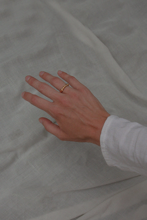 A textured band ring inspired by the sculptural surface of the moon, featuring a granulated, speckled silver finish. Elegant yet subtle, it complements both organic and minimalist jewelry styles. A distinctive everyday piece with a refined edge. Discover lunar-inspired design by UMIAR jewelry.