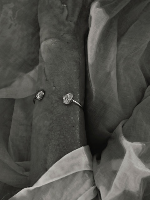 A rigid cuff bracelet adorned with realistic shell details that capture the essence of summer by the sea. Featuring shell elements measuring 15 × 13 mm, it blends decorative charm with classic elegance. Ideal for summer styling and refined everyday wear. Discover timeless seasonal design by UMIAR jewelry.